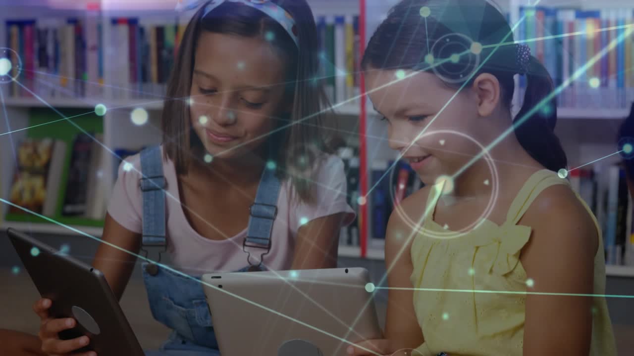 Girls tapping tablets in library while network overlay fading in sparking collaborative learning
