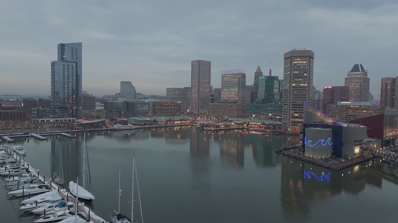 Inner harbor and skyline drone reveal shot at dusk, overcast weather