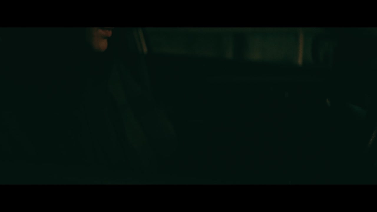 Person driving at night with playing cards in hand