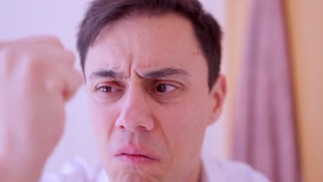 worried man examining hair loss in mirror