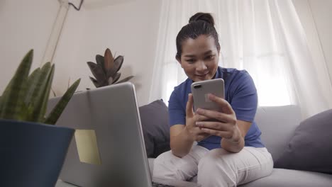 asian women are using smartphone with a profile for online shopping on a laptop