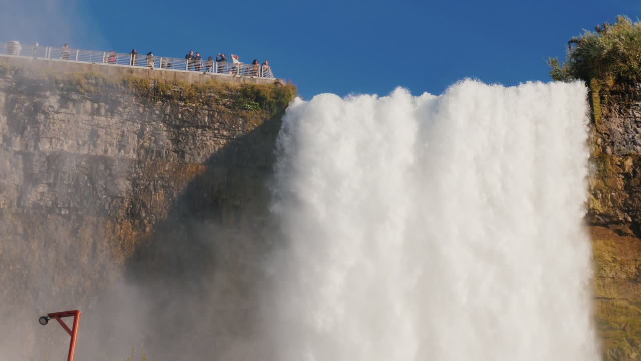 관광객들은 나이아가라 폭포를 관찰합니다.