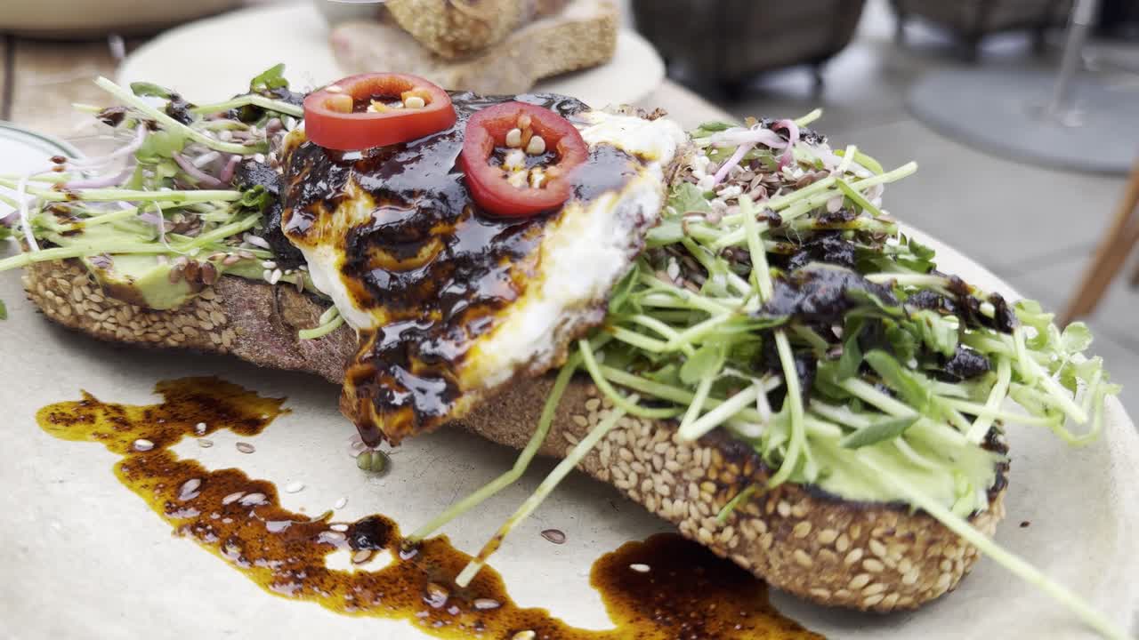 Avocado toast and cappuccino at a restaurant in Venice, California with video moving in.