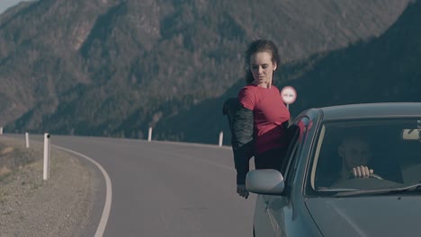 bruneta feliz viaja sentada en la ventana de un coche antiguo