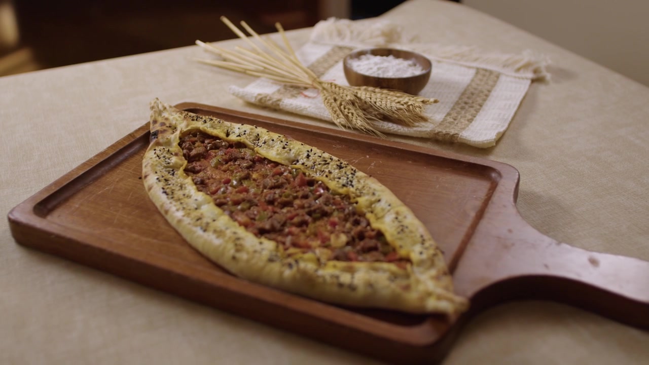 Freshly baked Turkish pide, a traditional dish with minced meat topping on a table