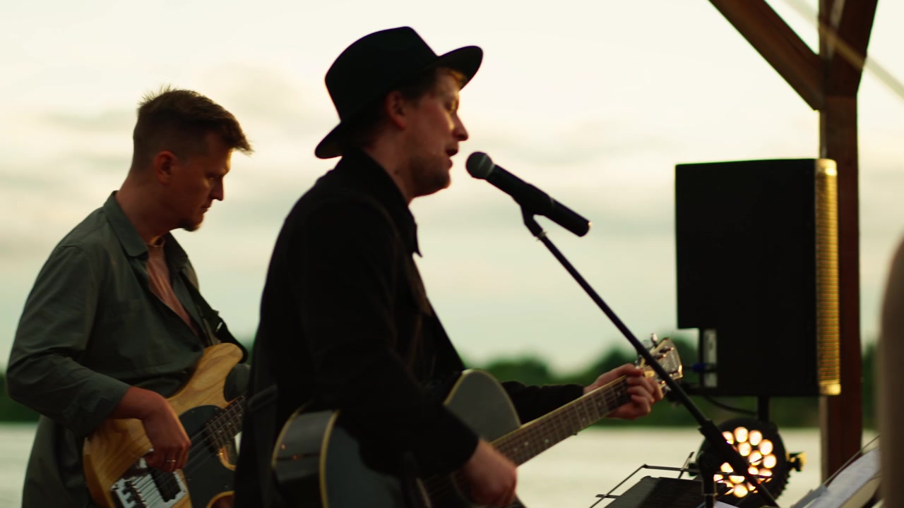 Musikband optræder live udendørs ved solnedgang