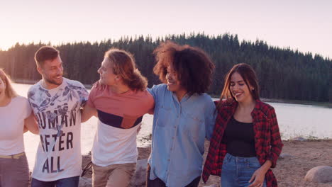 friends walking by the lake at sunset