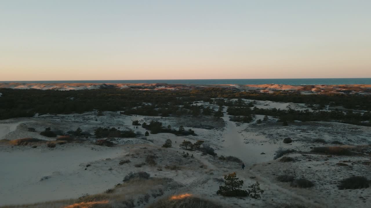 tomada aérea de descenso de personas explorando las dunas de provincetown al atardecer