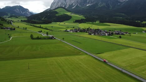 Serenidad-Alpina:-Toma-Aérea-De-4.000-Drones-De-Un-Camino-Brumoso-Desde-Graz-A-Hallstatt,-Los-Autos-Recorren-El-Campo-Austriaco-Con-Campos-Verdes-Perfectamente-Cortados-Y-Un-Impresionante-Panorama-De-Los-Alpes