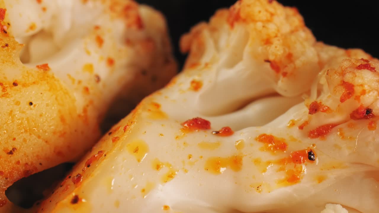 파프리카와 올리브 오일로 맛을 낸 구운 콜리플라워의 시네마틱 클로즈업 슬로우 팬