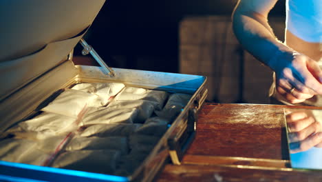 drug dealer places packets with psychotropic drugs. many types of drugs lay on the table in front of him. criminal business