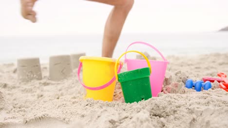 uomo che si schianta su un castello di sabbia sulla spiaggia