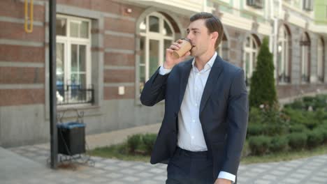 closeup man drinking hot coffee outdoor. businessman walking with hot of coffee