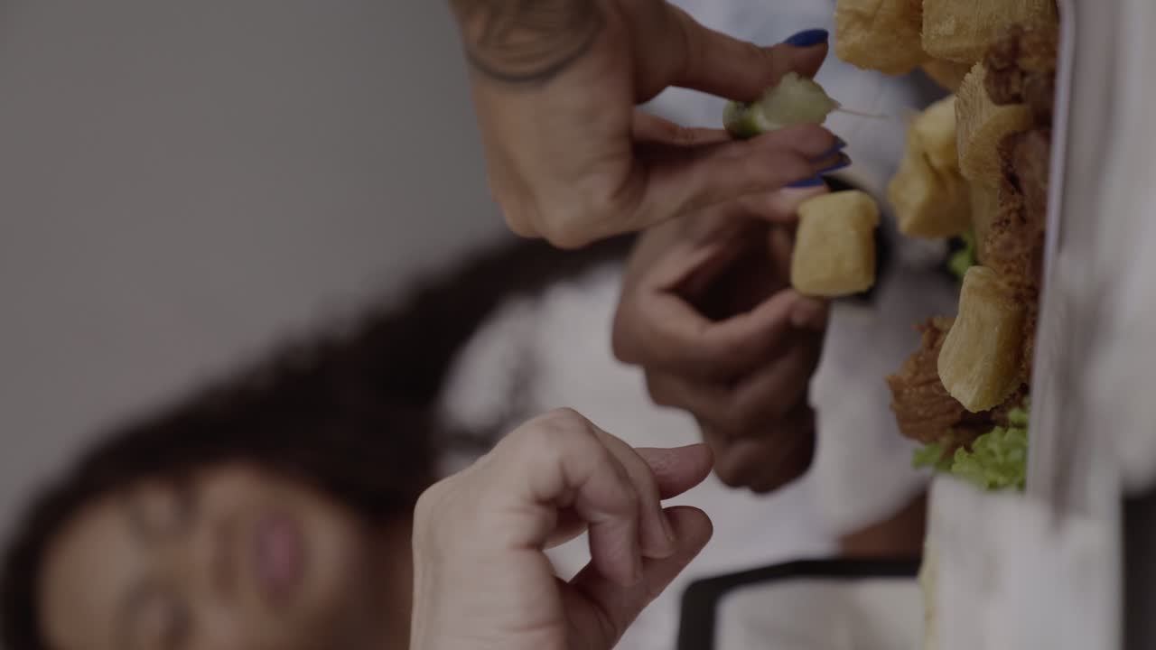 Close-up of a hand squeezing lime onto a plate of fried food