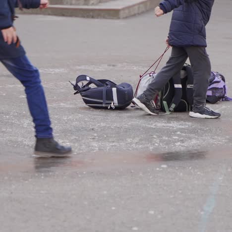 close-up of children's feet. happy school kids slide on the ice. frosty winter day.