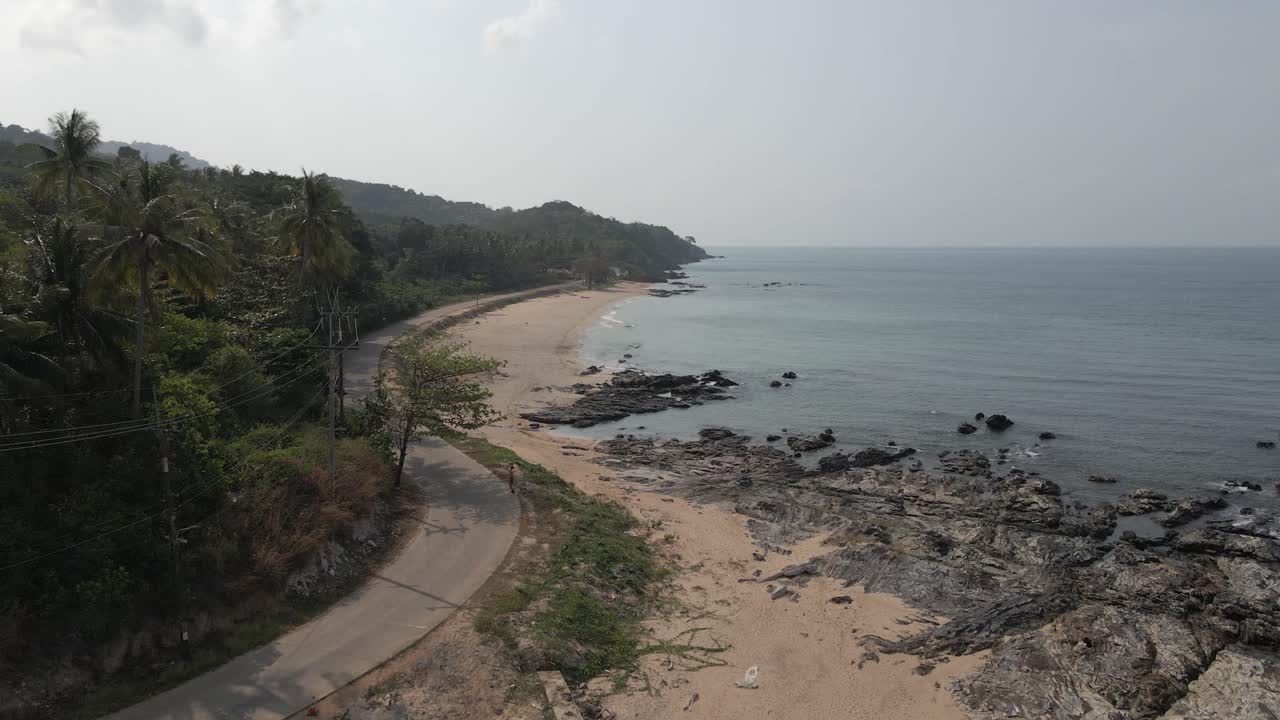 Una strada costiera tortuosa segue la tranquilla costa di Koh Lanta in Thailandia.