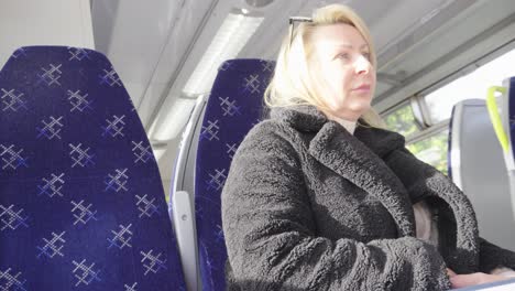 Mujer-Sentada-Esperando-Pacientemente-A-Que-El-Tren-Salga-De-La-Estación.