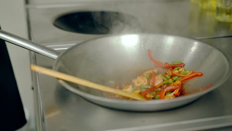 cerca de la sartén con aceite y verduras cocinando fajitas