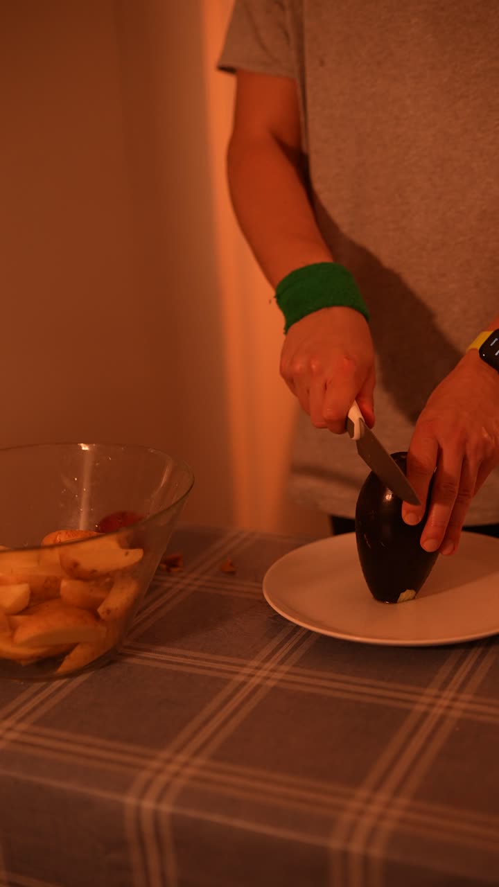 persona que corta berenjena y patatas