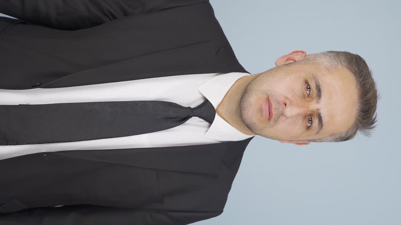 vídeo vertical de un hombre de negocios diciendo cállate a la cámara.