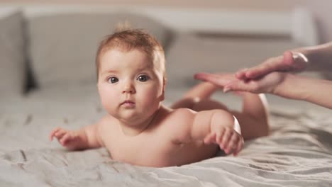 close-up of mother's hands apply oil on baby's back