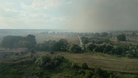 wildfire smoke spreads across rural landscapes near the odra river in szczecin, poland
