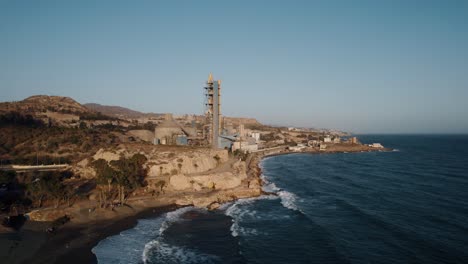 Un-Lento-Alejamiento-Cinematográfico-De-La-Fábrica-De-Cemento-Revela-La-Hermosa-Playa-Del-Peñón-Del-Cuervo-En-Málaga-España-Con-El-Agua-Azul-Oscuro-Del-Mar-De-Alborán