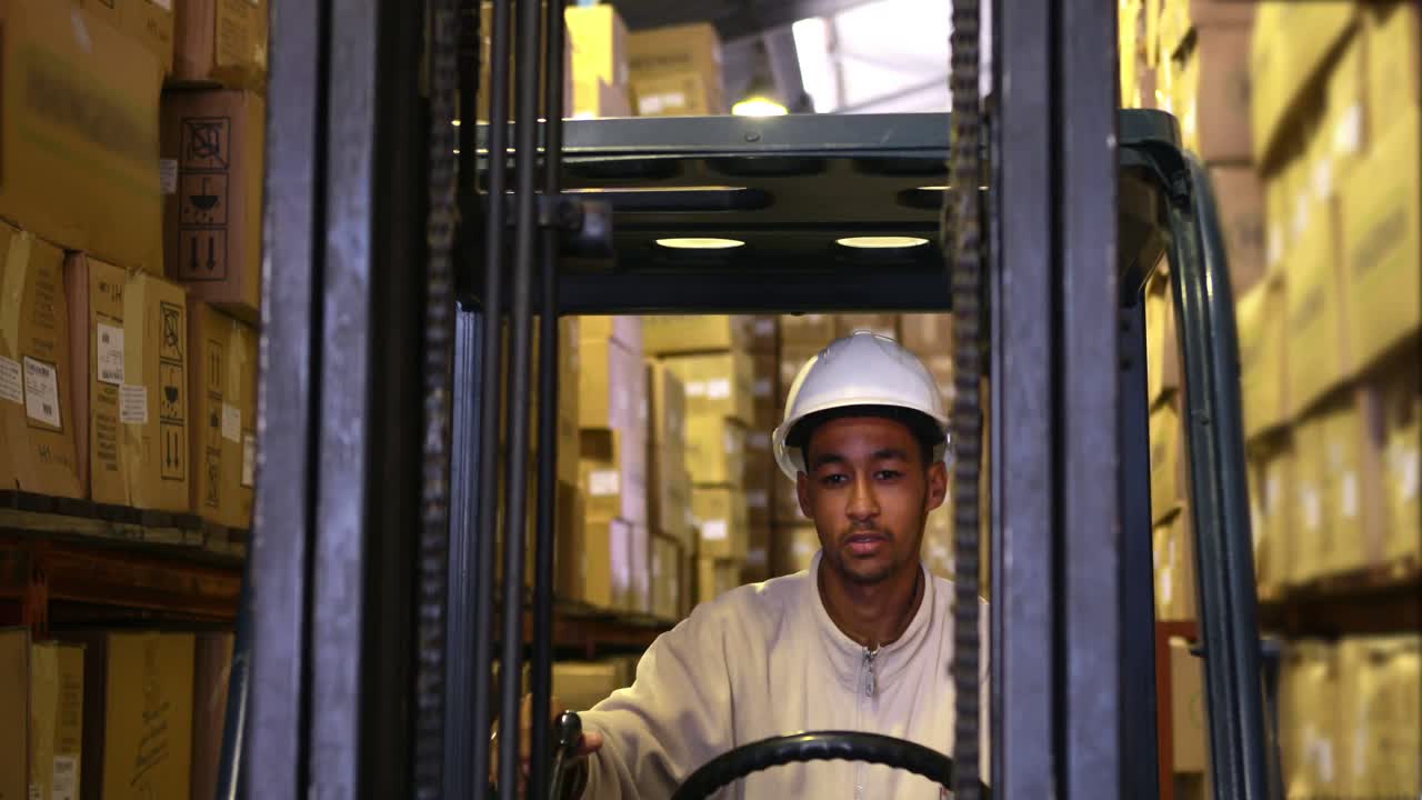 conductor de carretilla elevadora que opera una máquina con cajas en ella