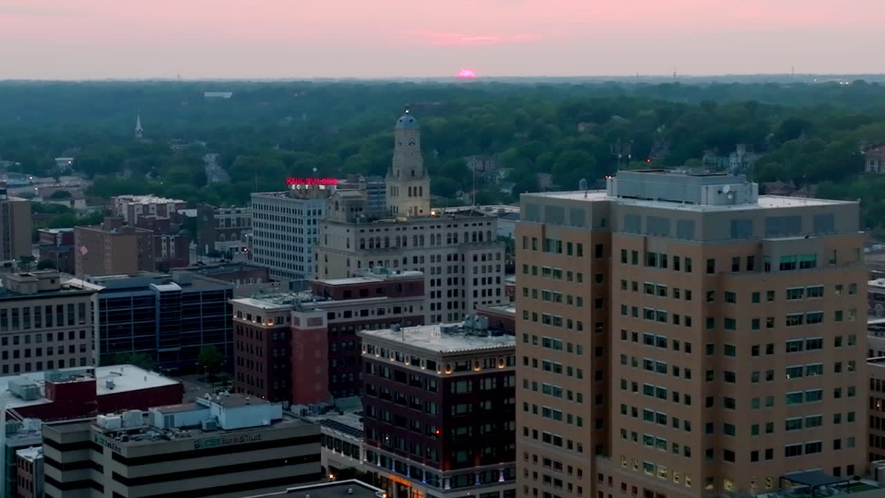 centro de davenport, iowa horizonte durante el atardecer con video de avión no tripulado de cerca paralaje tirando hacia atrás