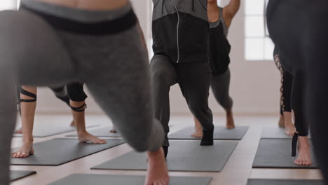 Gesunde-Yoga-Frau-Praktiziert-Krieger-Pose.-Junge-Muslimische-Frau-Mit-Kopftuch-Genießt-Den-Fitness-Lebensstil-Und-Trainiert-Im-Studio-Mit-Einer-Gruppe-Gemischtrassiger-Frauen