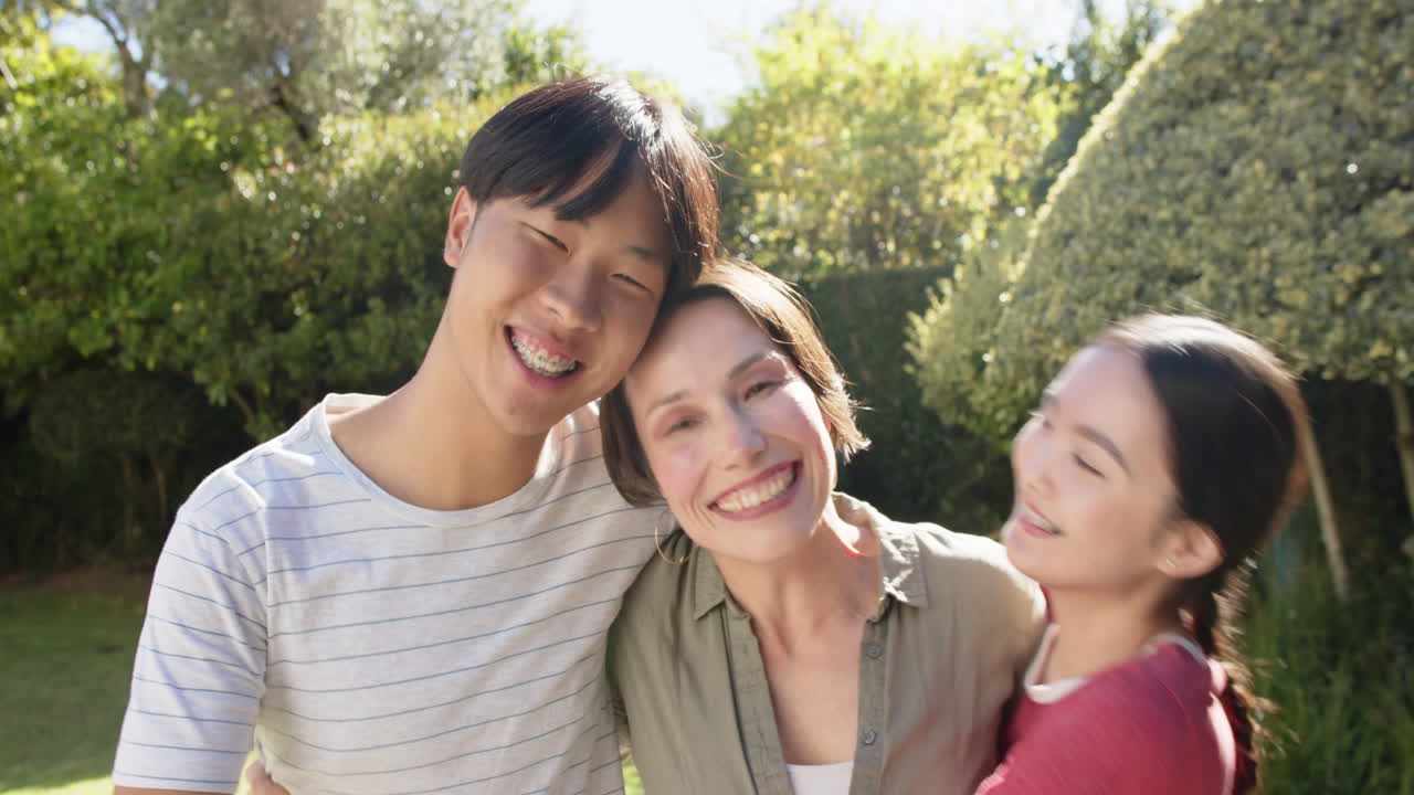 Smiling family embracing outdoors, enjoying quality time together in garden