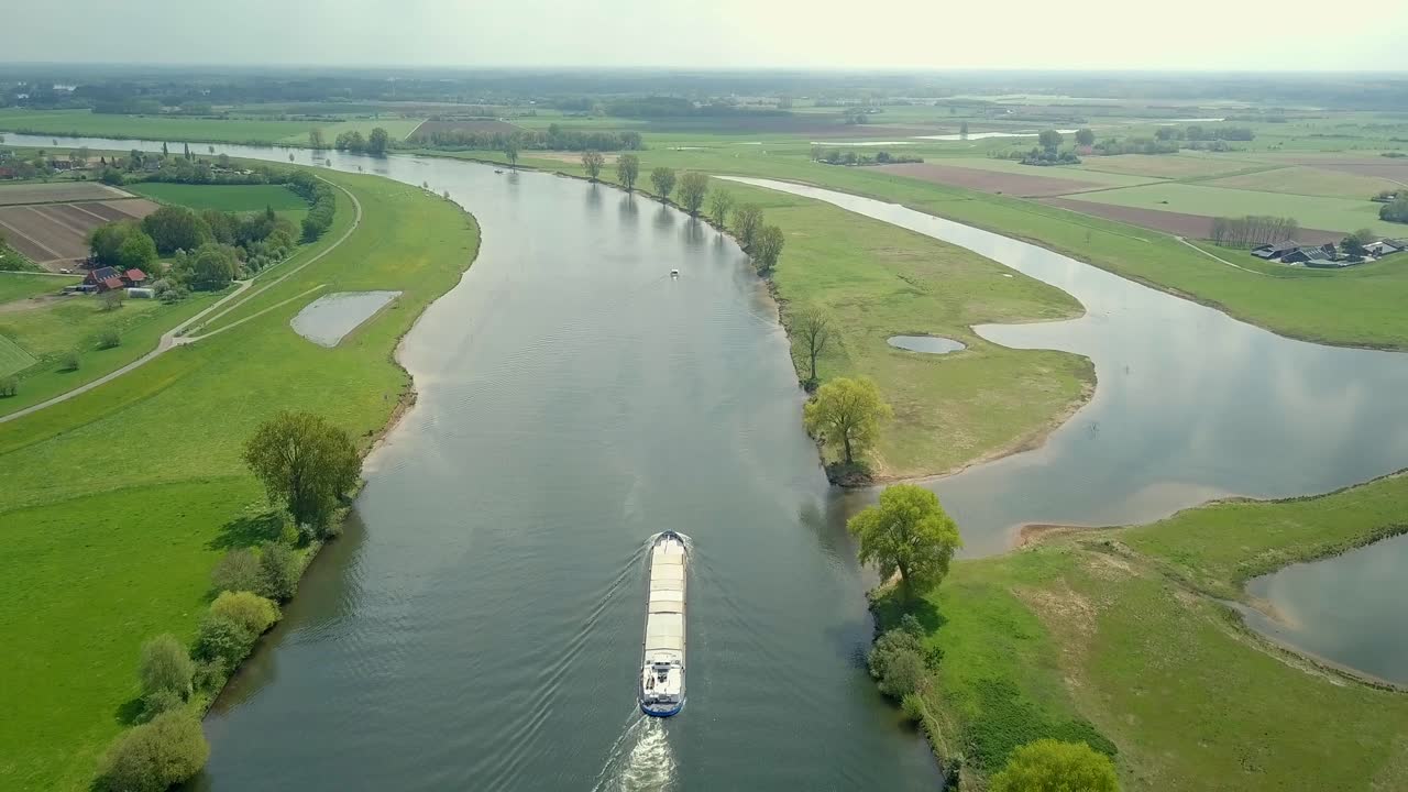 네덜란드, 유럽의 강에서 컨테이너 선박 위로 날아가는 장엄한 장면의 공중 드론 보기