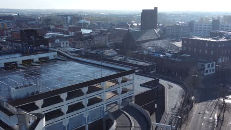 overhead aerial view above city multi storey car park quiet british urban public streets at sunrise right dolly