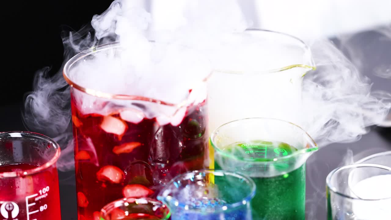 다채로운 액체와 증폭하는 연기가 있는 컵