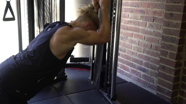 Tattoo man muscles in home gym cable ab crunch