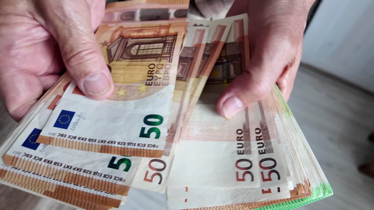hombre jubilado cuenta billetes de euro, ahorros para la vejez