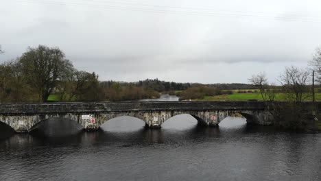 Aerial---Over-the-river-with-bridge-road-for-car-passing-through