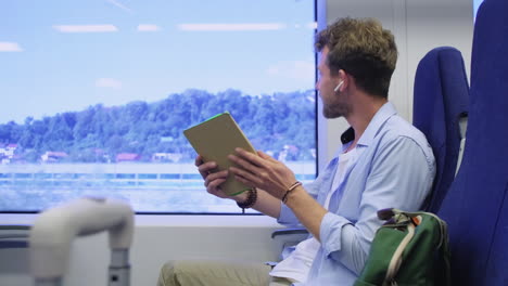 man using tablet on train