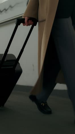 woman with luggage walking in airport terminal