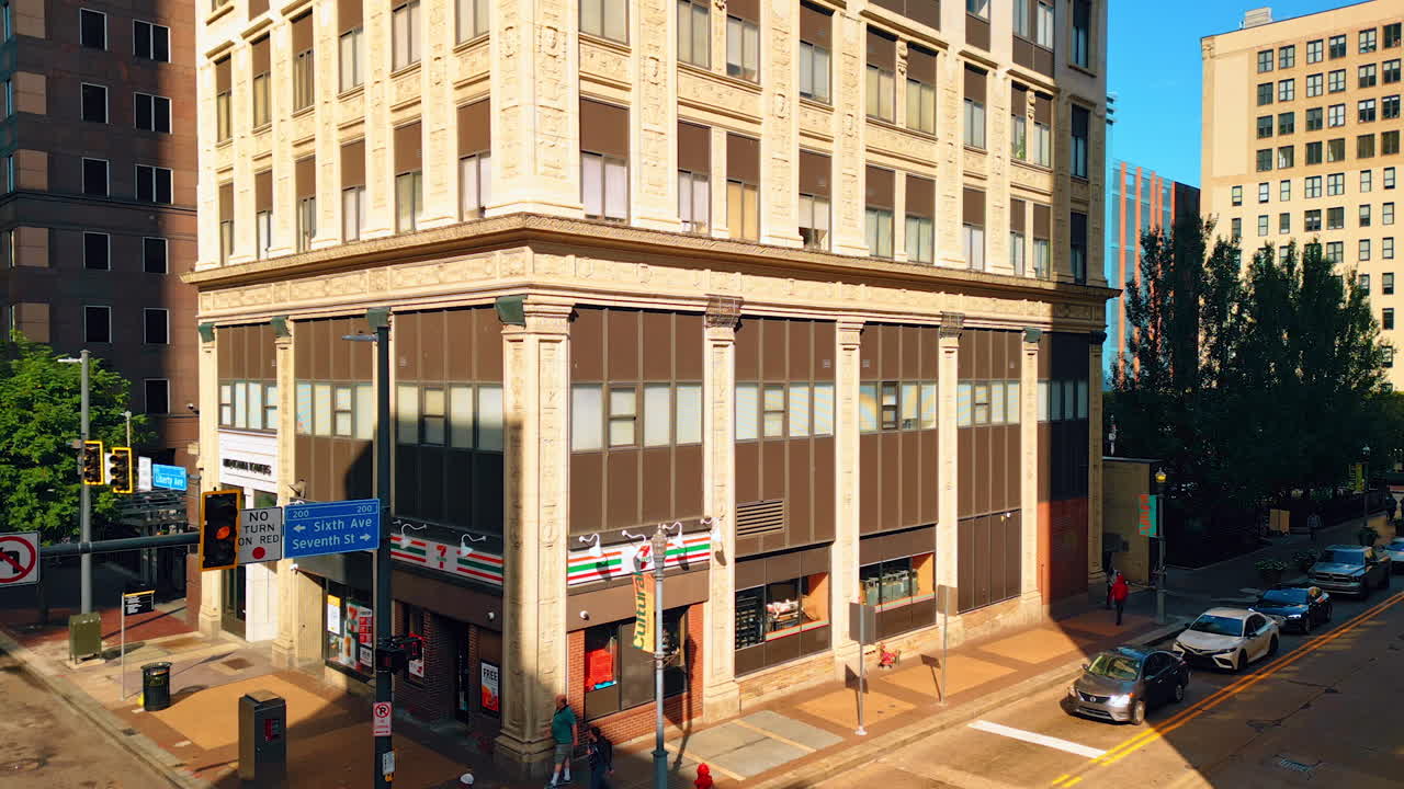 Piyysburgh, USA, 3 August 2025: Corner building and city street in Pittsburgh. An old corner building with shops and people walking in downtown Pittsburgh