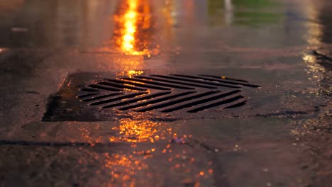 rain falling in slow motion down a sewer drain at night.