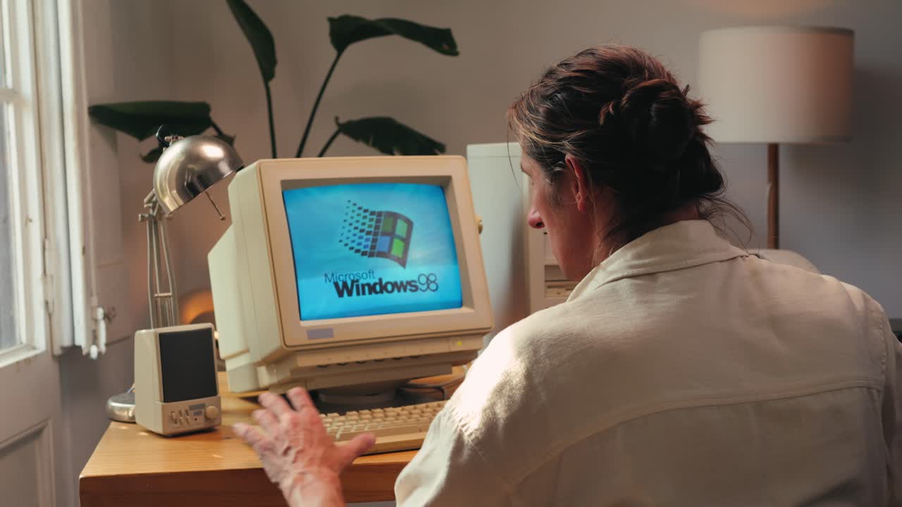 BARCELONA, SPAIN, 10 JUNE 2025. Man working and gaming on retro computer PC, IT engineer with vintage computer at home, using old fashion technology, close up of retro setup.