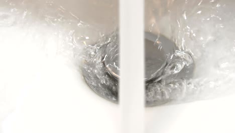 el agua gira por el desagüe del fregadero del inodoro.