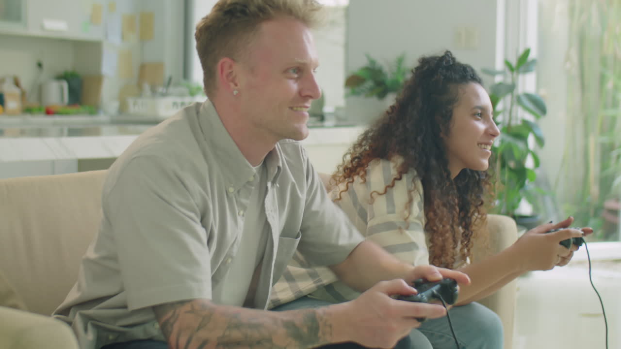 Young Couple Playing Console Game and Having Fun at Home