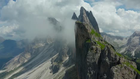 aerial rising above jagged cliff edge of seceda mountain in dolomites