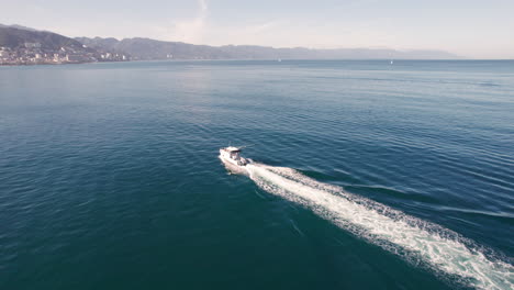 el video aéreo captura un yate desde la parte trasera, acercándose gradualmente y realizando una órbita sutil, mostrando el impresionante mar de puerto vallarta y su hermosa costa en el fondo