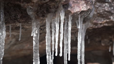 ice dams under rock in cold freezing winter landscape, close up