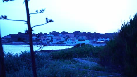 Pequeño-Pueblo-En-La-Costa-De-Francia-Con-Muchas-Pequeñas-Casas-Blancas-En-El-Ambiente-Nocturno-Y-Luz-Azul.