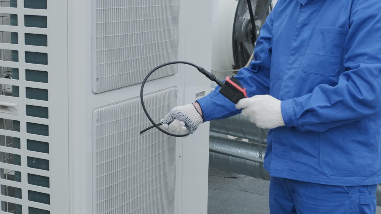 The technician uses a digital camera to check the clogging of the heat exchanger