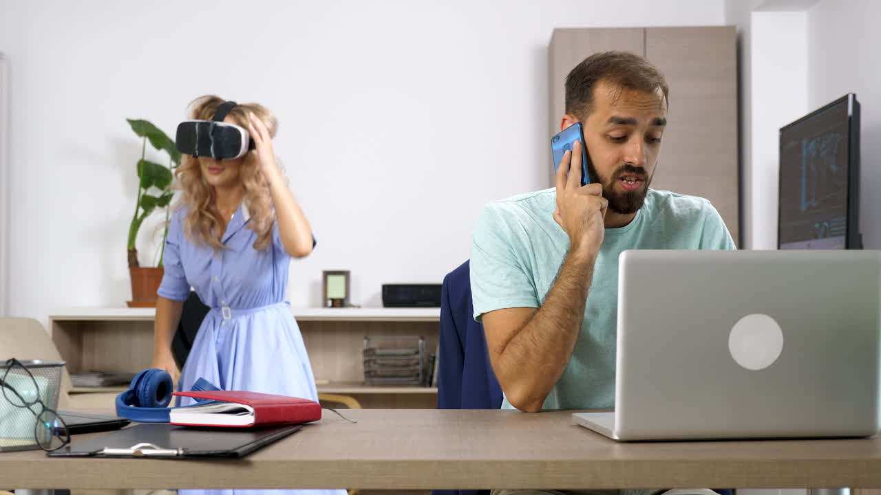 People using VR headset and talking on the phone in a modern office